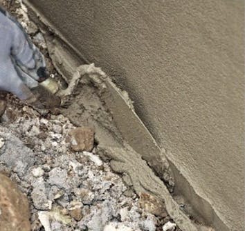 Pusse grunnmur: Nederst rettes laget opp med en murerskje Pusse grunnmur: Nederst rettes laget opp med en murerskje